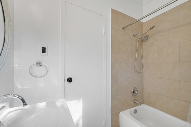 bathroom featuring tiled shower / bath combo and sink