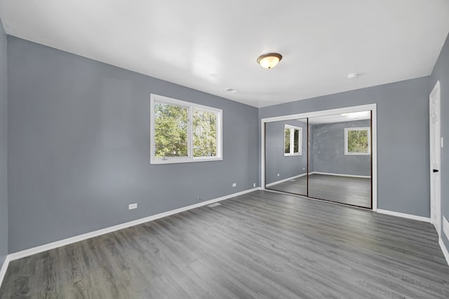 unfurnished bedroom featuring a closet and dark hardwood / wood-style floors