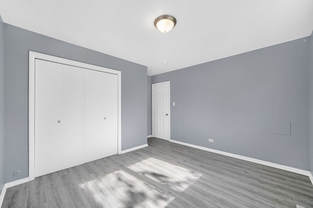 unfurnished bedroom featuring hardwood / wood-style flooring and a closet