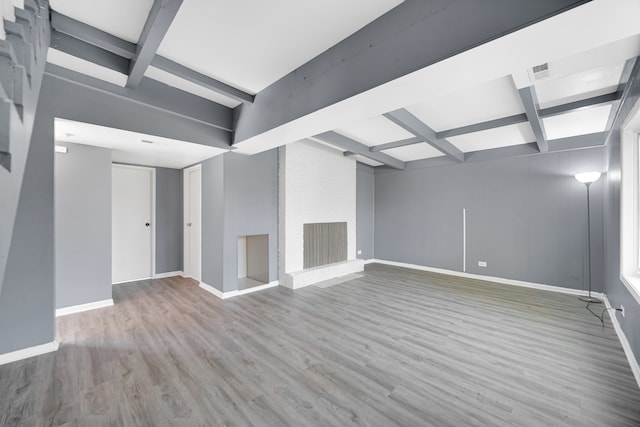 basement featuring wood-type flooring and a brick fireplace