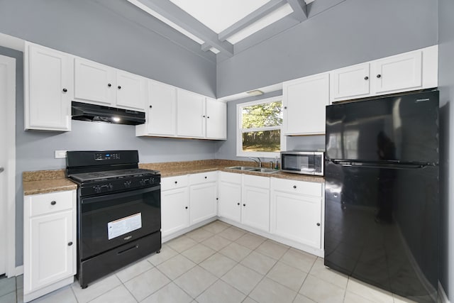 kitchen featuring white cabinets, light tile patterned flooring, sink, black appliances, and dark stone counters