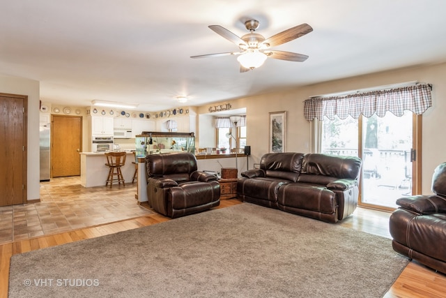 living room featuring light wood-type flooring and ceiling fan