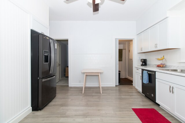 kitchen with white cabinets, stainless steel fridge, sink, black dishwasher, and light wood-type flooring