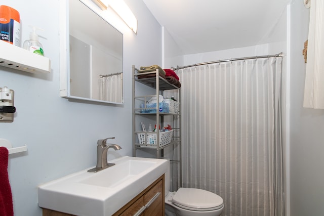 bathroom with a shower with shower curtain, vanity, and toilet