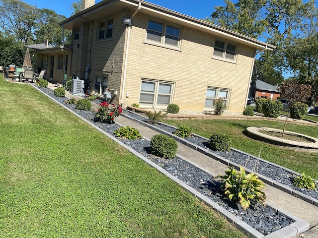 view of side of home with a lawn and ac unit