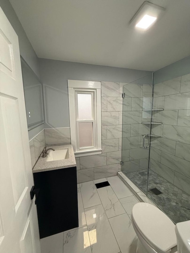 bathroom featuring vanity, toilet, and a shower with shower door