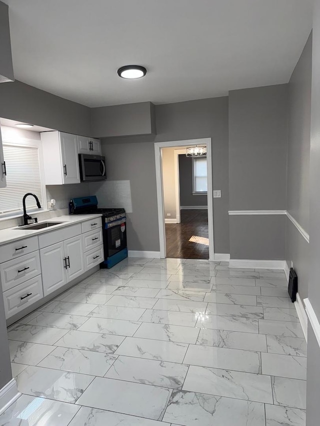 kitchen featuring white cabinets, sink, and black range with gas cooktop