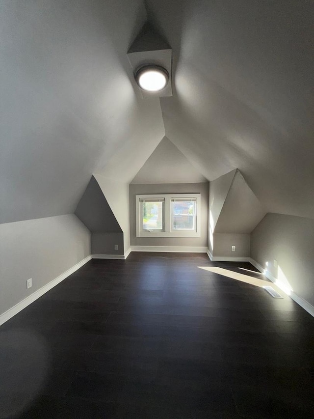 bonus room featuring vaulted ceiling and dark hardwood / wood-style floors