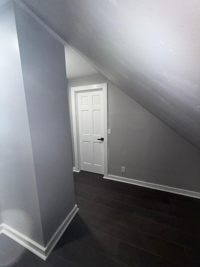 additional living space featuring dark hardwood / wood-style floors and vaulted ceiling