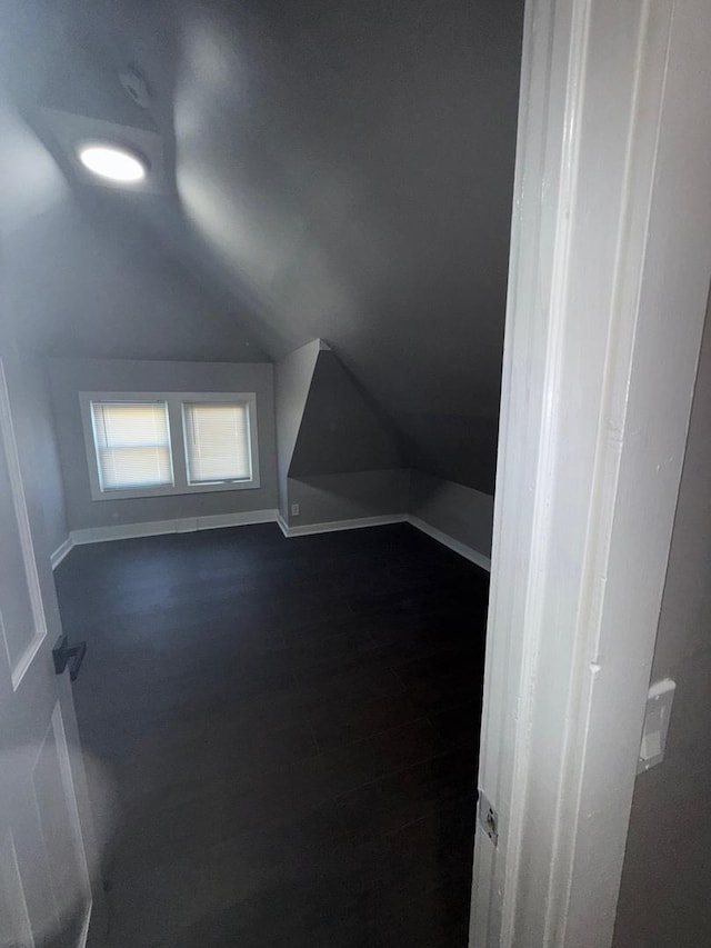 additional living space with dark hardwood / wood-style flooring and lofted ceiling