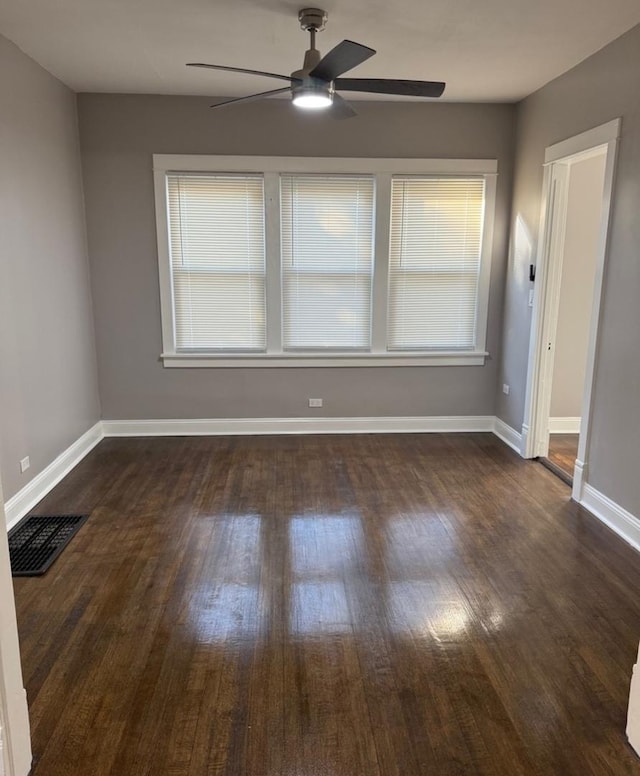 spare room featuring ceiling fan, dark wood-type flooring, and a wealth of natural light