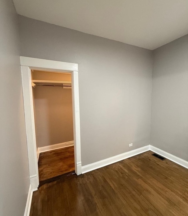 unfurnished bedroom with dark hardwood / wood-style flooring and a closet