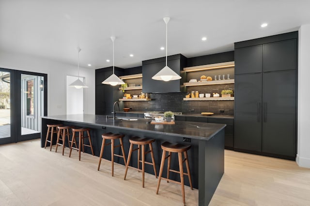 kitchen with pendant lighting, decorative backsplash, a kitchen breakfast bar, and a spacious island