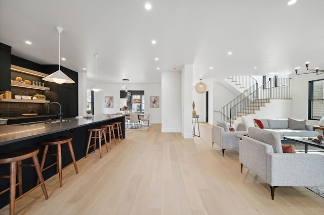 living room with light hardwood / wood-style floors and a notable chandelier