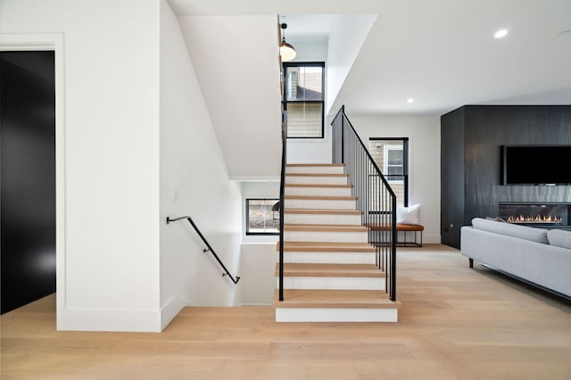 stairway featuring a fireplace and hardwood / wood-style floors