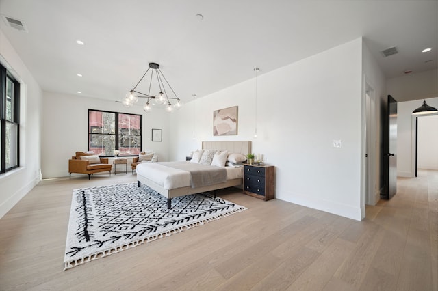 bedroom with a notable chandelier and light hardwood / wood-style flooring