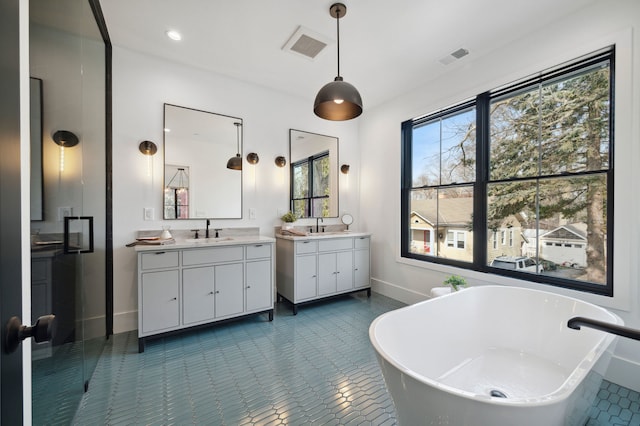 bathroom featuring tile patterned flooring, vanity, a washtub, and plenty of natural light