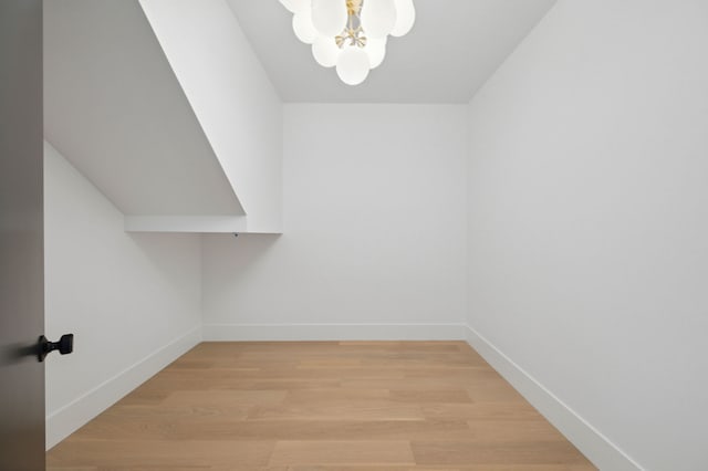 walk in closet with an inviting chandelier and light hardwood / wood-style floors