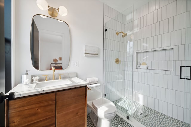 bathroom featuring vanity, toilet, a shower with door, and tile patterned floors