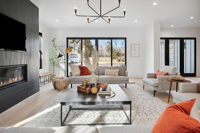 living room featuring a tiled fireplace and a notable chandelier