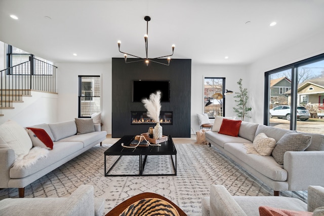 living room with an inviting chandelier and a large fireplace