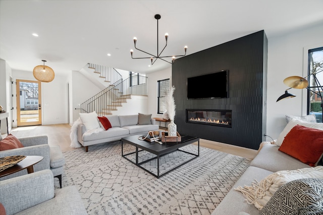 living room with a notable chandelier, a fireplace, and plenty of natural light