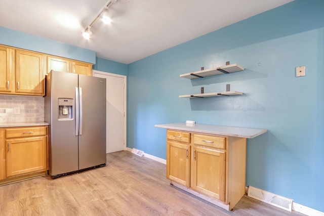 kitchen featuring backsplash, track lighting, stainless steel refrigerator with ice dispenser, and light wood-type flooring