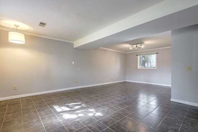 empty room featuring dark tile patterned flooring and crown molding