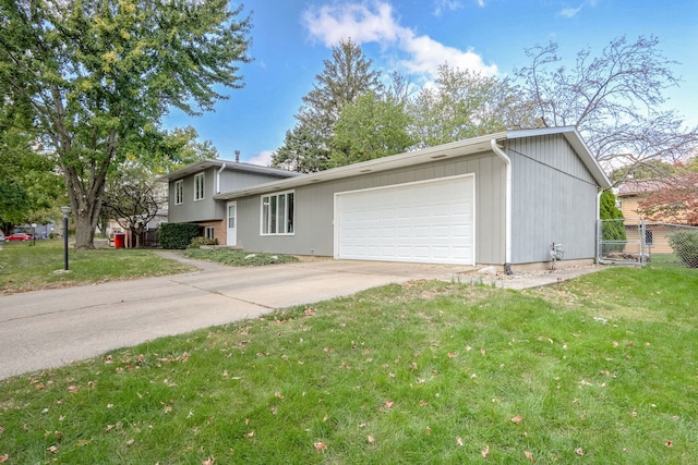 tri-level home with a garage and a front lawn