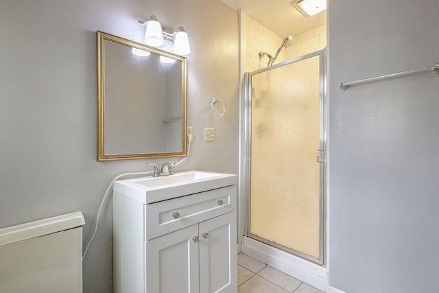 bathroom with a shower with door, vanity, toilet, and tile patterned flooring