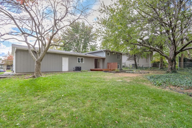 rear view of house featuring a yard and central AC unit