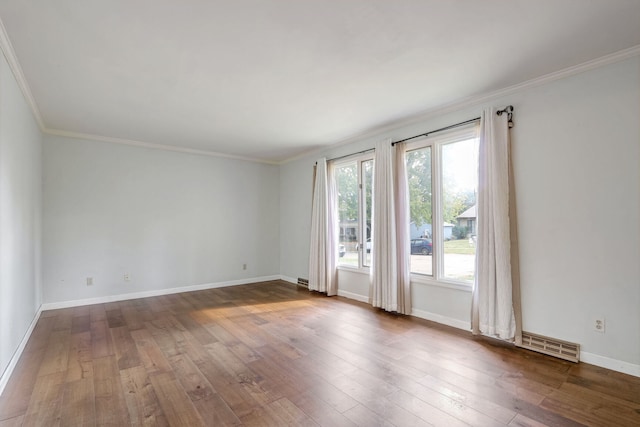 spare room with ornamental molding and dark wood-type flooring