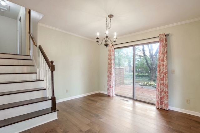 spare room with an inviting chandelier, dark hardwood / wood-style floors, and crown molding