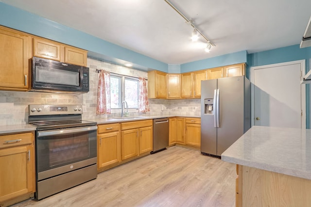 kitchen with decorative backsplash, track lighting, light hardwood / wood-style flooring, sink, and stainless steel appliances