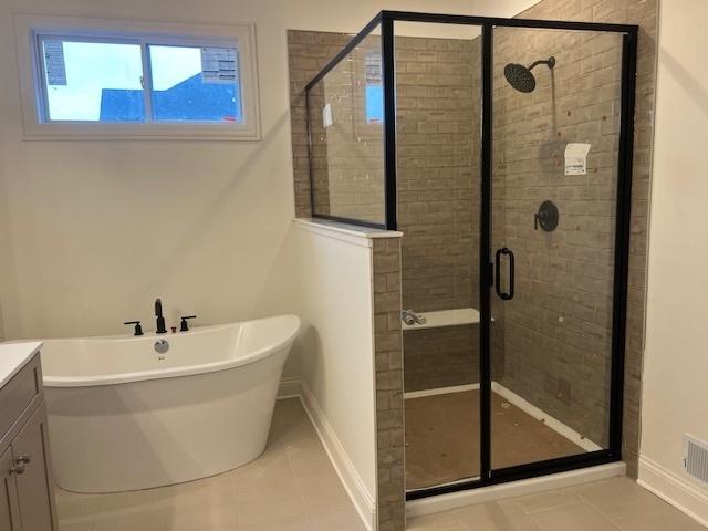 bathroom featuring vanity, tile patterned floors, and separate shower and tub