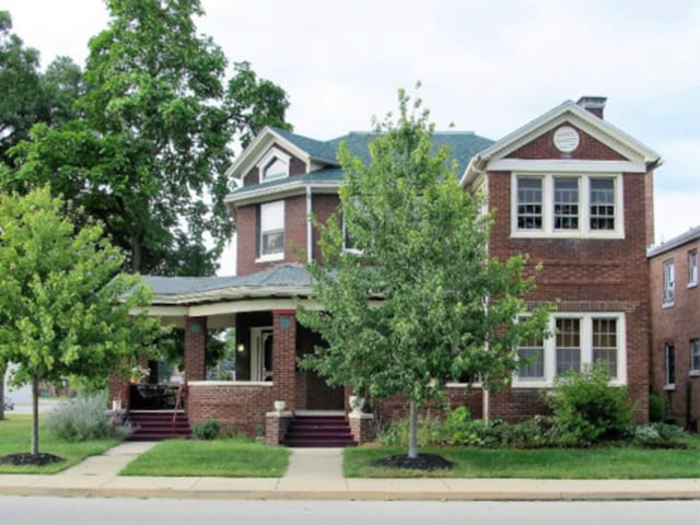 view of front of property featuring brick siding and a porch