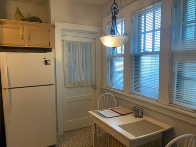 kitchen with decorative light fixtures and white fridge