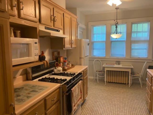 kitchen with radiator heating unit, white appliances, pendant lighting, light countertops, and under cabinet range hood