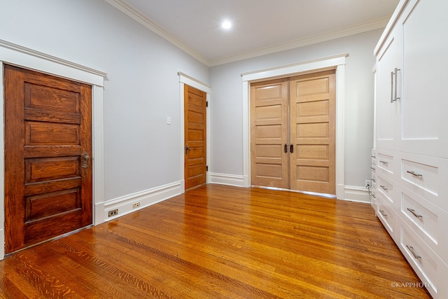 entryway featuring hardwood / wood-style floors and crown molding