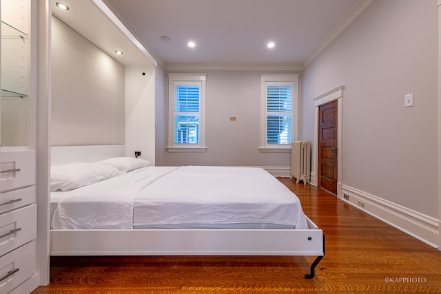 bedroom featuring wood-type flooring, crown molding, and radiator heating unit