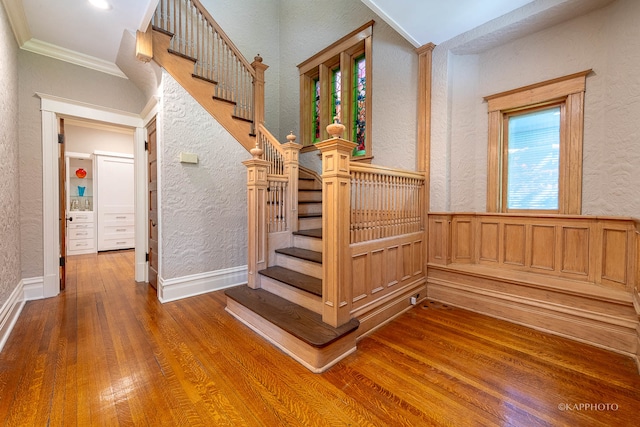 stairs featuring hardwood / wood-style flooring and crown molding