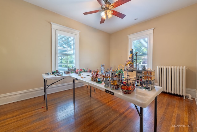 rec room with radiator, ceiling fan, and dark hardwood / wood-style floors