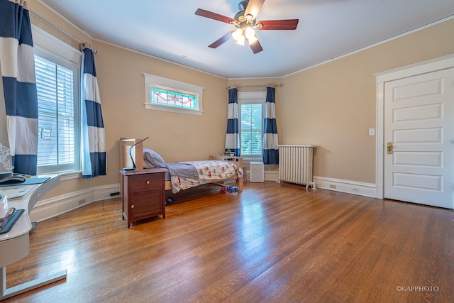 bedroom with multiple windows, radiator, and ceiling fan