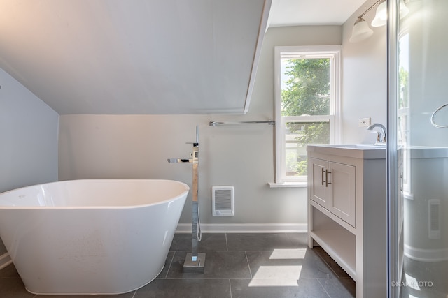 bathroom featuring a bathtub, vaulted ceiling, heating unit, vanity, and tile patterned floors