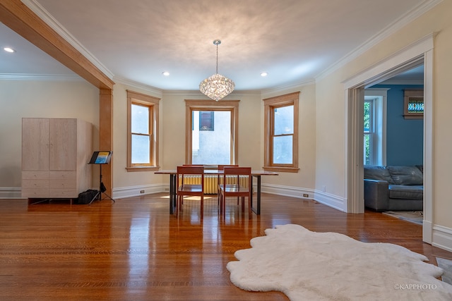 dining room with dark hardwood / wood-style floors, a chandelier, and crown molding