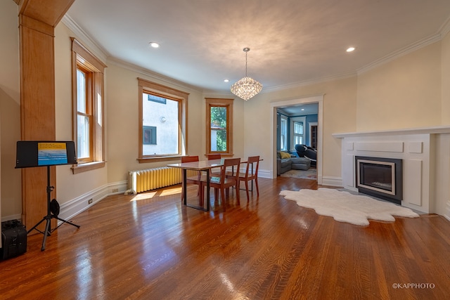 dining area with radiator, ornamental molding, a chandelier, and hardwood / wood-style floors