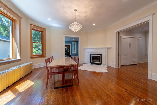 dining area featuring ornamental molding, radiator, an inviting chandelier, and dark hardwood / wood-style flooring