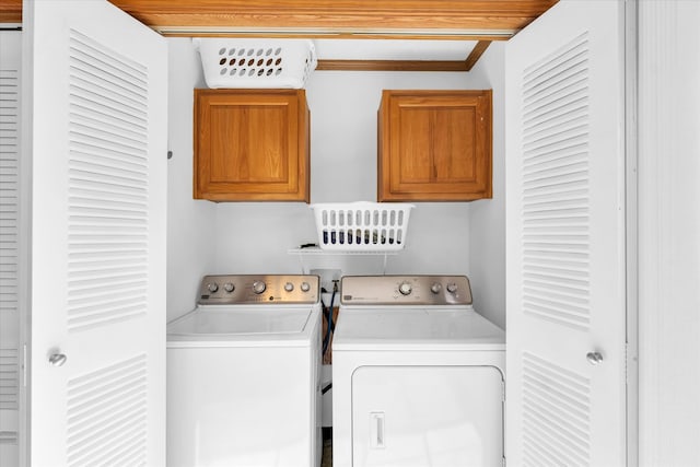 laundry room with cabinets, washer and dryer, and ornamental molding