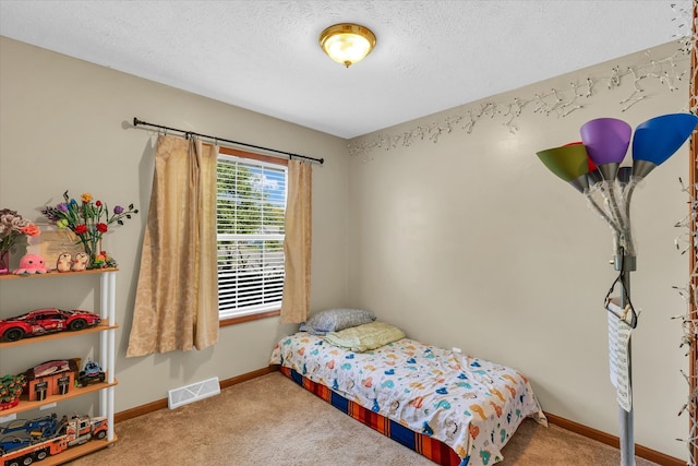 bedroom with a textured ceiling and carpet floors