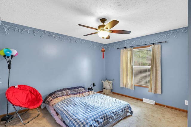 carpeted bedroom featuring a textured ceiling and ceiling fan